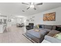 Spacious living room with tile flooring, a ceiling fan, and ample natural light creating an inviting atmosphere at 9815 Carabiner Way, Land O Lakes, FL 34637