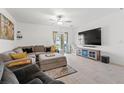 Living room with tile floors, a ceiling fan, and sliding glass doors that offer a seamless indoor-outdoor flow at 9815 Carabiner Way, Land O Lakes, FL 34637