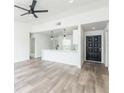 Open-concept living room features laminate floors, modern ceiling fan, and flows into the kitchen at 1040 Bridlewood Way, Brandon, FL 33511