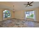 Bright living room with tiled floors, large windows, chandelier, and ceiling fan at 10430 Crestfield Dr, Riverview, FL 33569