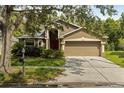 Charming home featuring a two-car garage, neutral-tone stucco, and well-maintained landscaping at 10462 Lucaya Dr, Tampa, FL 33647
