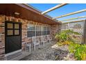 Inviting outdoor patio area with brick paving, a pergola, and comfortable seating for enjoying the outdoors at 105 Melrose Dr, Safety Harbor, FL 34695