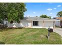 Charming single-story home with a well-maintained lawn and covered porch at 10730 Premier Ave, Port Richey, FL 34668