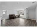 Bright living room featuring wood floors, a comfortable sofa, and ample natural light at 10730 Premier Ave, Port Richey, FL 34668