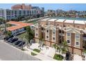 Exterior shot of a three-story townhouse with stucco finish, small balconies, and private parking spaces at 120 Brightwater Dr, Clearwater Beach, FL 33767
