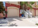 Garage and entryway featuring a beige garage door, concrete driveway, and manicured landscaping at 120 Brightwater Dr, Clearwater Beach, FL 33767