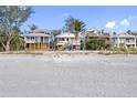Beautiful beach homes sitting on a sandy beach with clear blue skies at 12458 1St W St, Treasure Island, FL 33706