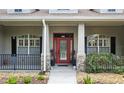 Charming home featuring a vibrant red front door, decorative stone accents, and meticulous landscaping at 13122 Done Groven Dr, Dover, FL 33527