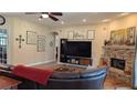 Inviting living room featuring a brick fireplace, wooden floors, and built-in shelving at 13122 Done Groven Dr, Dover, FL 33527