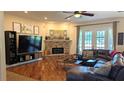 Spacious living room featuring hardwood floors, brick fireplace, and French doors at 13122 Done Groven Dr, Dover, FL 33527