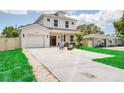 Charming two-story home with a manicured lawn and cozy outdoor seating area in front at 1410 Nebraska Ave, Palm Harbor, FL 34683