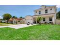 Charming two-story home with a manicured lawn and cozy outdoor seating area in front at 1410 Nebraska Ave, Palm Harbor, FL 34683