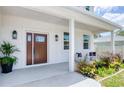 Inviting front porch featuring a stylish front door, decorative plants, and comfortable seating at 1410 Nebraska Ave, Palm Harbor, FL 34683