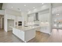 Bright kitchen with white cabinets, a large island, and modern stainless steel appliances at 14279 Swiss Bridge Dr, Riverview, FL 33579
