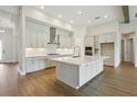 Modern kitchen boasts an island with a marble countertop, ample white cabinetry, and stainless steel appliances at 14523 Swiss Bridge Dr, Lithia, FL 33547