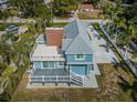 Expansive aerial view of a blue two-story home with a spacious rooftop deck, showcasing the property's unique design and curb appeal at 160 Shore Dr, Palm Harbor, FL 34683