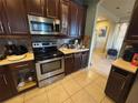 Kitchen featuring dark cabinetry, stainless steel appliances, and light countertops at 16027 Vine Cliff Ave, Hudson, FL 34667