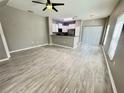 Open-concept living space featuring wood-look flooring, large windows, and a modern kitchen at 1878 Greenwood Valley Dr, Plant City, FL 33563