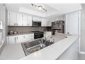 The cozy kitchen features bright white cabinets and modern stainless steel appliances at 2621 Cove Cay Dr # 309, Clearwater, FL 33760