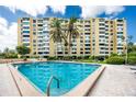 A tranquil pool scene with palm trees offers a serene escape at this condo, under a bright blue sky at 2621 Cove Cay Dr # 309, Clearwater, FL 33760