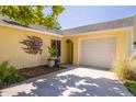 Beautful yellow single-Gathering home with a white garage door and shade from a large tree at 310 Arbor E Dr, Palm Harbor, FL 34683