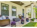 Inviting front porch with cushioned wicker furniture and potted plants, perfect for relaxing outdoors at 311 12Th N Ave, St Petersburg, FL 33701