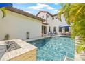 Beautiful backyard pool with a travertine deck, a fire feature, and comfortable lounge furniture at 311 12Th N Ave, St Petersburg, FL 33701