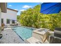 Backyard pool with fire feature, outdoor seating and lush tropical foliage for a private oasis at 311 12Th N Ave, St Petersburg, FL 33701