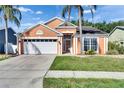 Single-Gathering home with an attached two-car garage, and tropical landscaping at 318 Lookout Dr, Apollo Beach, FL 33572