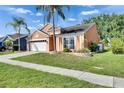 Charming single-story home with a well-maintained lawn, mature landscaping and two-car garage at 318 Lookout Dr, Apollo Beach, FL 33572