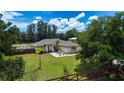 Landscaped front lawn and mature trees give the home natural beauty at 408 River Bed Ct, Wimauma, FL 33598