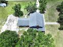 Aerial view of a home with a gray roof, surrounded by lush trees and green lawns at 5007 Booth Rd, Plant City, FL 33565