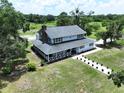 Beautifully landscaped two-story home with a long walkway, mature trees and a large, grassy yard at 5007 Booth Rd, Plant City, FL 33565