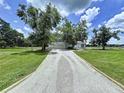 Long gravel driveway leading to a well-maintained house with ample green space at 5007 Booth Rd, Plant City, FL 33565