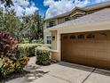 Spacious three-car garage featuring decorative doors, and lush landscaping surrounding the driveway at 5315 Cedarshake Ln, Valrico, FL 33596