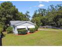 A quaint home with a well-manicured lawn and awning-covered windows at 5906 12Th St, Zephyrhills, FL 33542