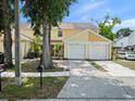 Two-story townhome with attached garage and a well-kept lawn and landscaping at 6114 Oak Cluster Cir, Tampa, FL 33634