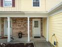Inviting front porch with brick accents and white support columns and a nice flower bed at 6114 Oak Cluster Cir, Tampa, FL 33634