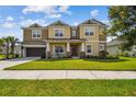 Inviting two-story home featuring a covered front porch and well-manicured lawn at 7024 Bradbury Cir, Wesley Chapel, FL 33545