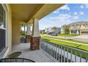 Relaxing covered front porch with stone columns and seating area with views of the neighborhood at 7024 Bradbury Cir, Wesley Chapel, FL 33545