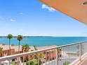 Expansive balcony view overlooking palm trees, the bay, and neighboring orange condo community at 7430 Sunshine Skyway S Ln # 602, St Petersburg, FL 33711