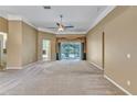Spacious living room with plush carpeting, neutral tones, and sliding glass doors to pool at 9242 Brindlewood Dr, Odessa, FL 33556