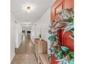 Inviting foyer with a decorative wreath on the red front door, complemented by wood-look floors and recessed lighting at 11551 Brighton Knoll Loop, Riverview, FL 33579
