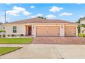 Beautiful single-story home featuring a three-car garage, brick driveway, and well-maintained landscaping at 11551 Brighton Knoll Loop, Riverview, FL 33579