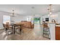 Open-concept living room featuring hardwood floors, a dining area, a large sofa, and access to the outdoor space at 11551 Brighton Knoll Loop, Riverview, FL 33579