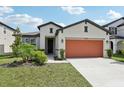Attractive single-story home featuring a two-car garage, lush landscaping, and a welcoming entrance at 13515 Palmera Vista Dr, Riverview, FL 33579