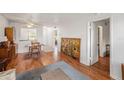 Open-concept living and dining area featuring wood floors and natural light from windows at 13710 Mission Oaks Blvd # 2A, Seminole, FL 33776