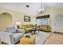 Bright living room with comfortable seating, decorative lamps, and a vaulted ceiling at 13814 Lavender Ave, Hudson, FL 34667