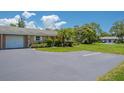 Charming villa featuring a well-manicured lawn, an attached garage and lush landscaping at 1510 Palmer Ct, Palm Harbor, FL 34685