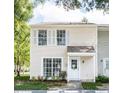Charming two-story townhouse showcasing white shutters and a covered front porch, offering a cozy curb appeal at 16175 Rambling Vine E Dr, Tampa, FL 33624